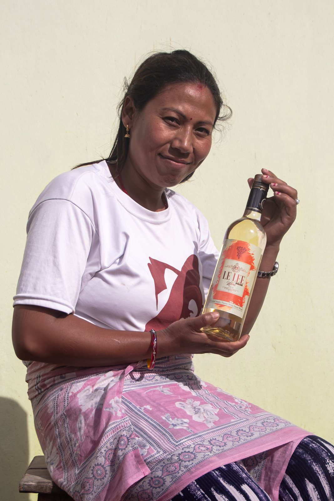 A smiling maker seated with a bottle of Yacon Sweet White